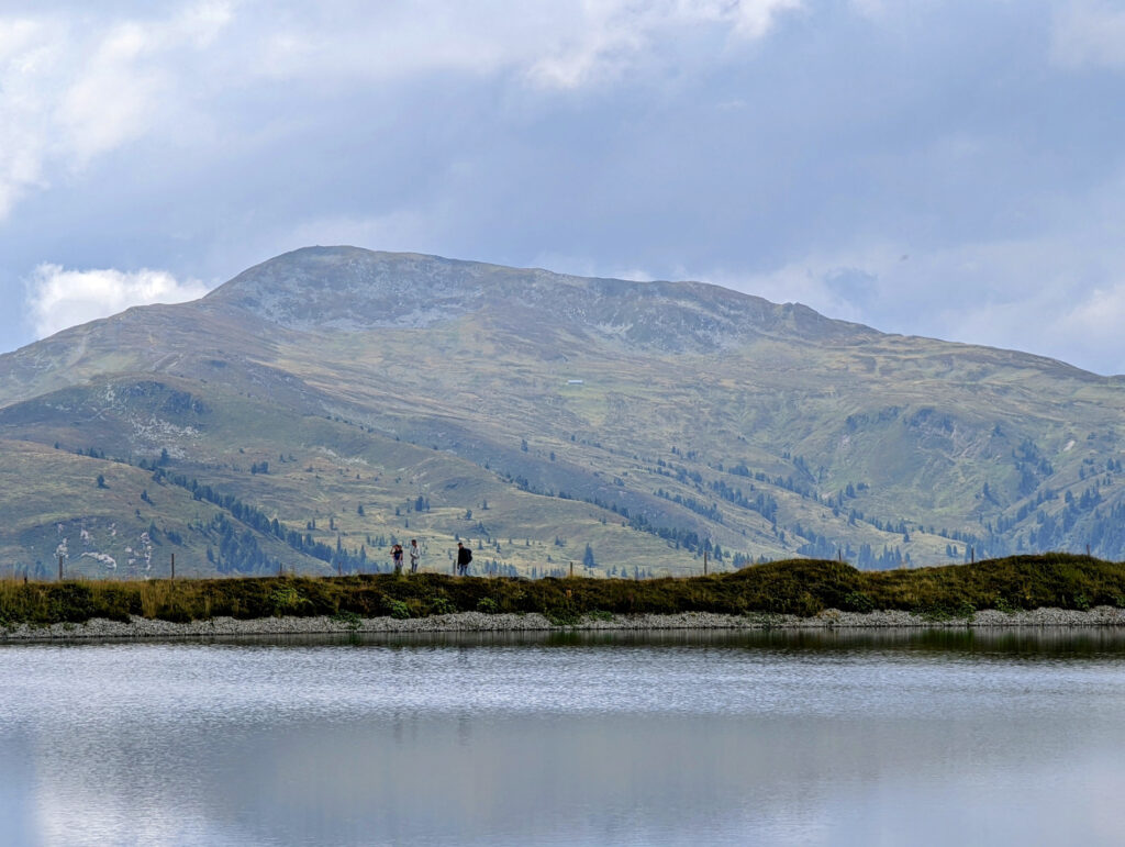 Klares Wasser eines Speichersees am Resterkogel mit Felsen und dem Himmel, ideal für Wasserspaß im Familienurlaub.
