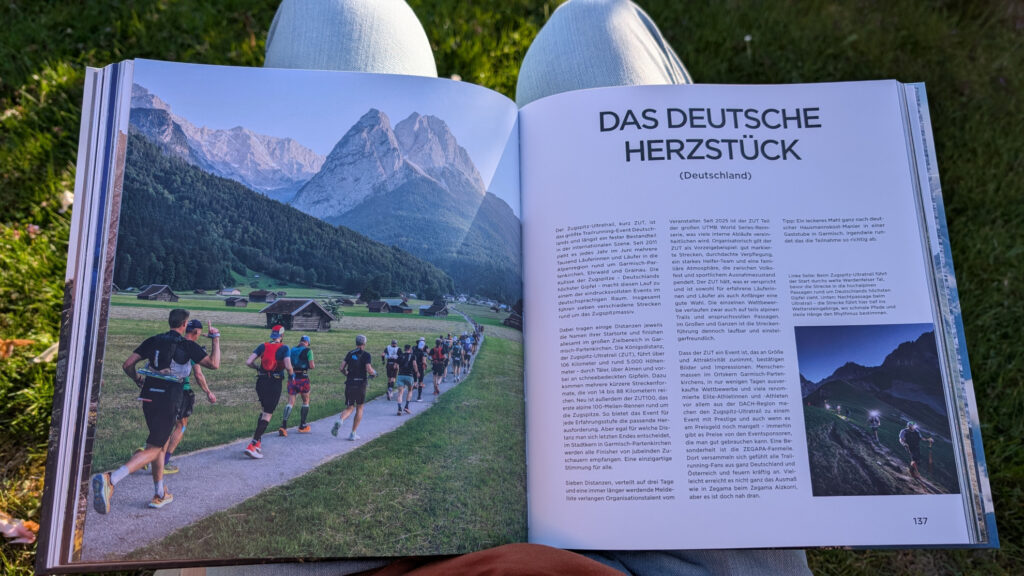 Aufgeschlagene Seite im Buch 'OFF TRACK' über den Zugspitz Ultratrail (ZUT) mit einem Foto von Läufern im Tal vor dem Bergmassiv.